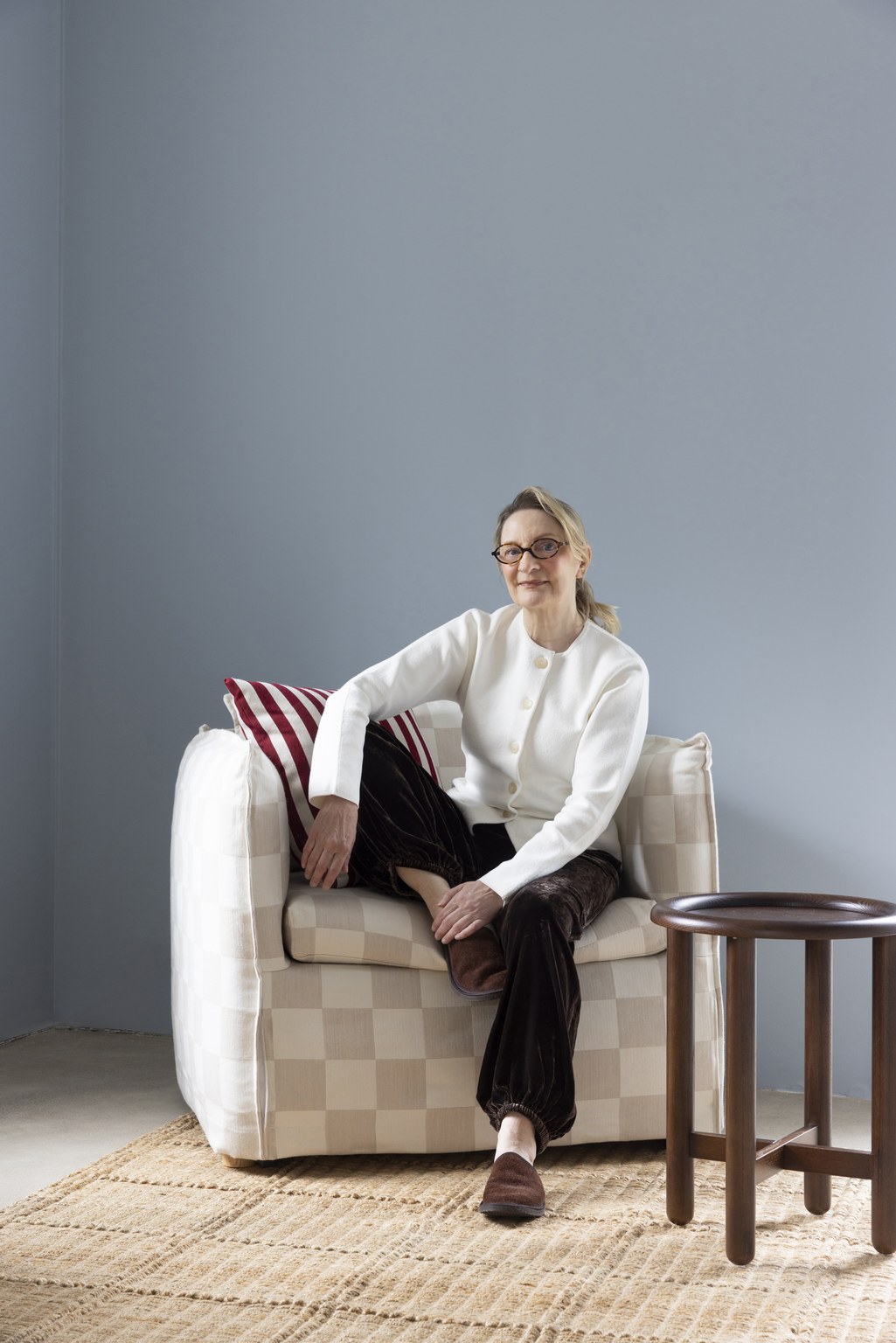 Anne Melender istuu Hakolan Layers Filippa -vuodetuolissa vierellään Layers Button-sivupöytä suklaanruskeana.